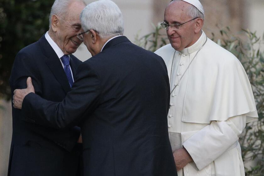 Pope Francis looks on as Israel's President Shimon Peres, left, and Palestinian President Mahmoud Abbas greet each other Sunday during an evening of peace prayers in the Vatican gardens.