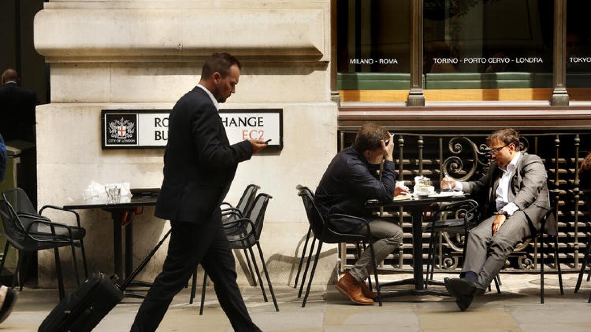 Near the Royal Exchange building in London, men take a break from work.