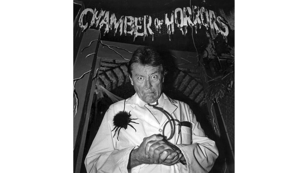 1987 photo of Bobby Pickett in a white coat with a fake spider under sign that reads Chamber of Horrors