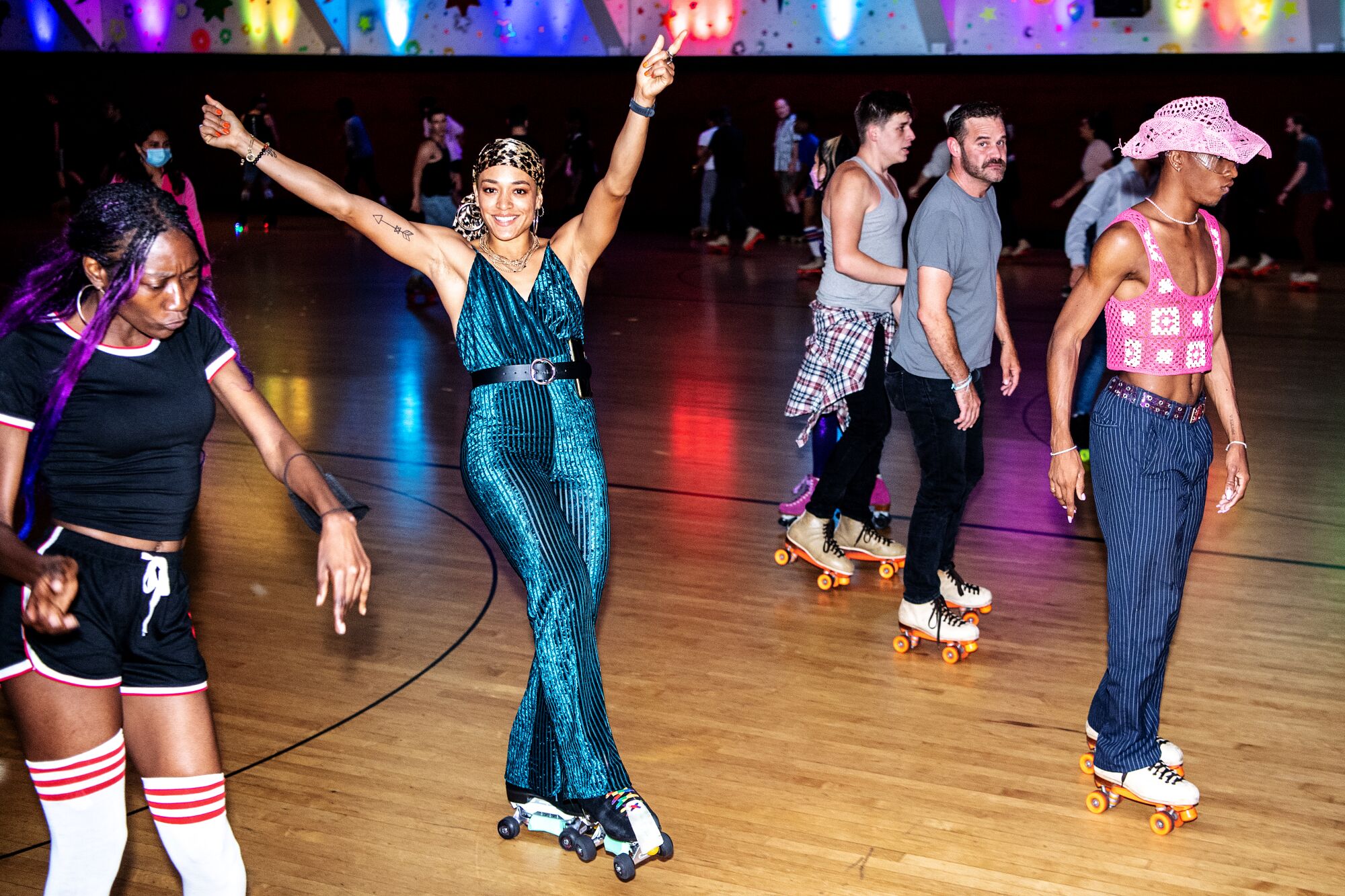 A woman skates with her arms raised in joy.