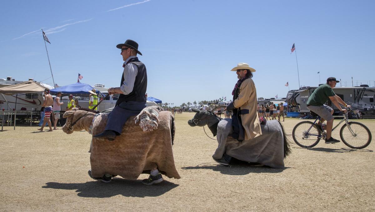 Slim, left, and Curly, from Morro Bay Fables of the West, parade their small horse costumes through the RV Resort.