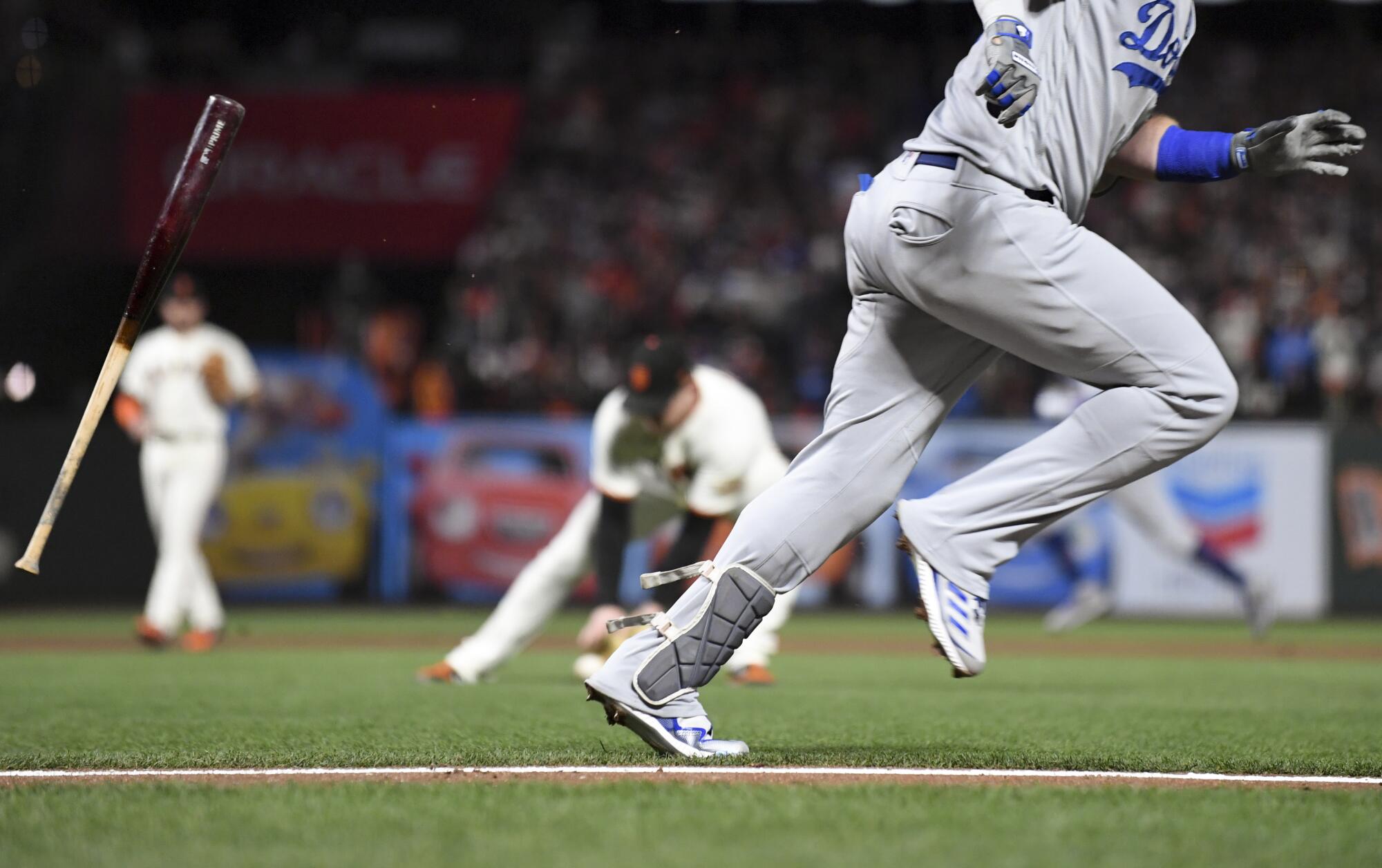 The Dodgers' Justin Turner tosses his bat on an infield grounder