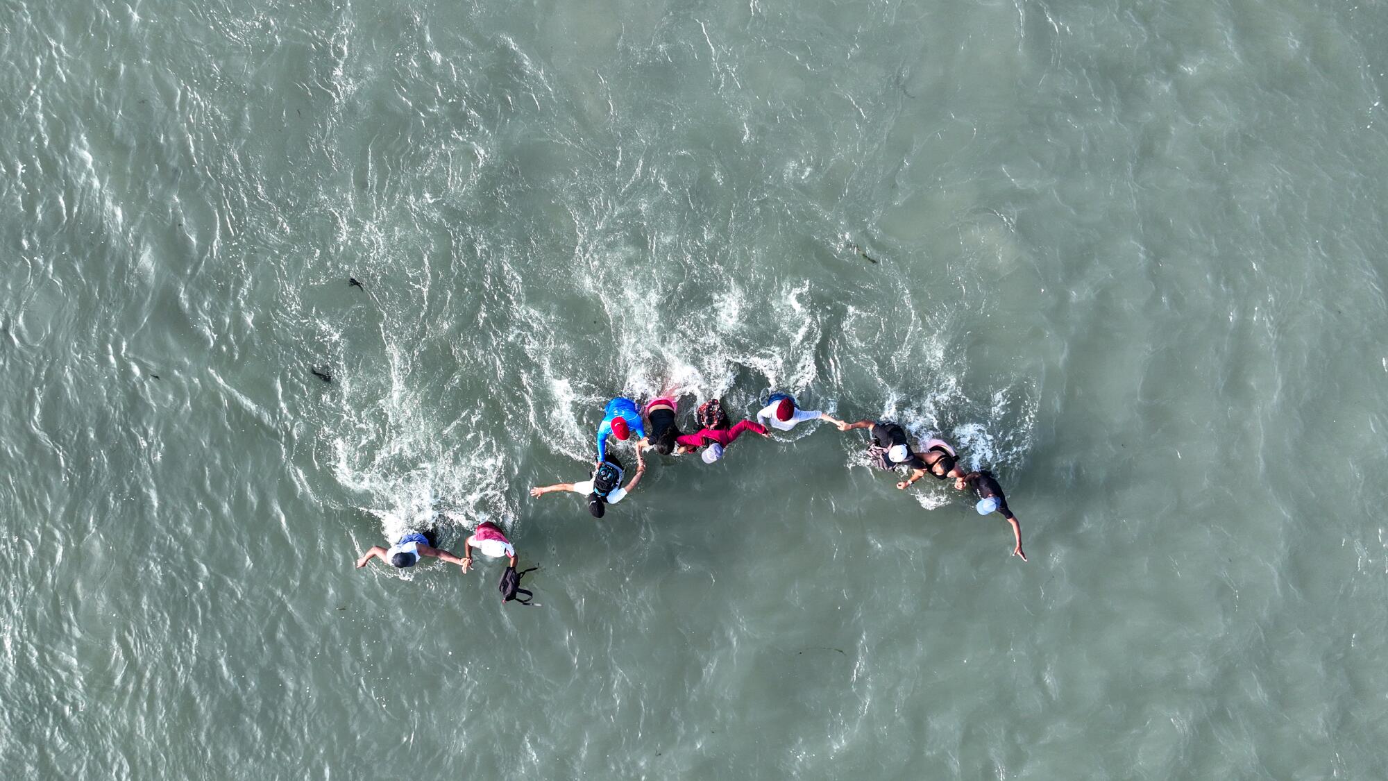 Migrants wade across the Rio Grande from Mexico.