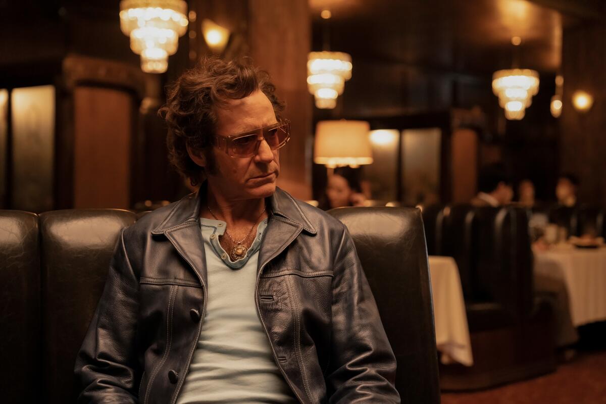 A man in a restaurant wearing sunglasses in "The Sympathizer."