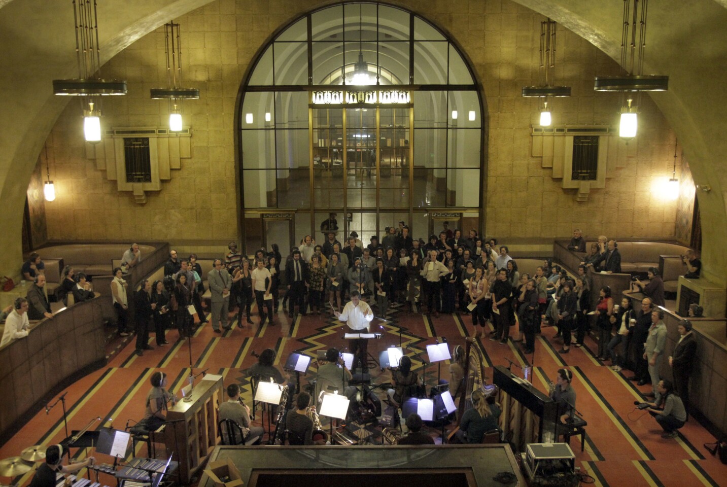 The orchestra conducts a dress rehearsal of the opera "Invisible Cities" in Union Station in Los Angeles on Oct. 17, 2013. The performance of The Industry company's new opera, based on Italo Calvino's novel with music by composer Christopher Cerrone, uses remote audio devices that allow performers and audience members wearing headsets to mingle among the train passengers and experience the opera environmentally.