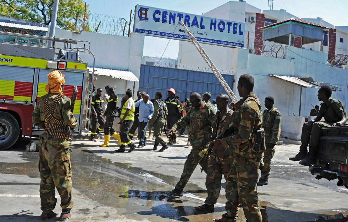 Somali security forces, paramedics and firefighters stand outside the Central Hotel in Mogadishu after a terror attack on Feb. 20.