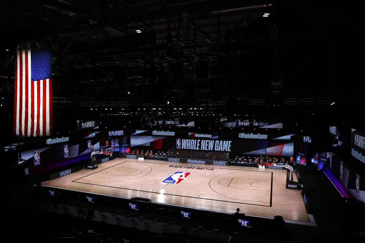 An empty court and bench are shown following the scheduled start time between the Milwaukee Bucks and Orlando Magic.