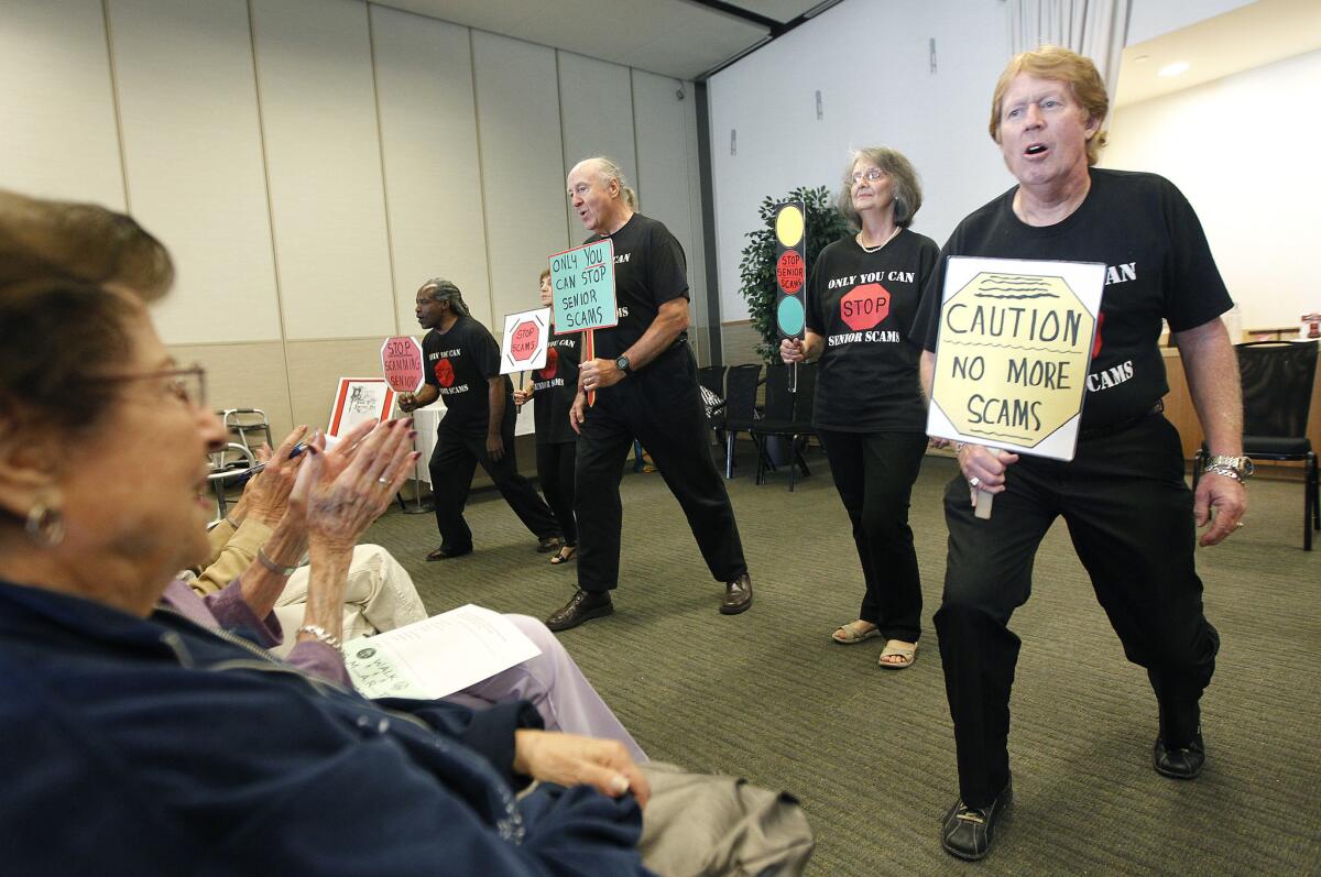 Participants with the Stop Senior Scams Acting Program, including Jimi Poulin, 65, right, perform a skit at Temple Judea in Tarzana.