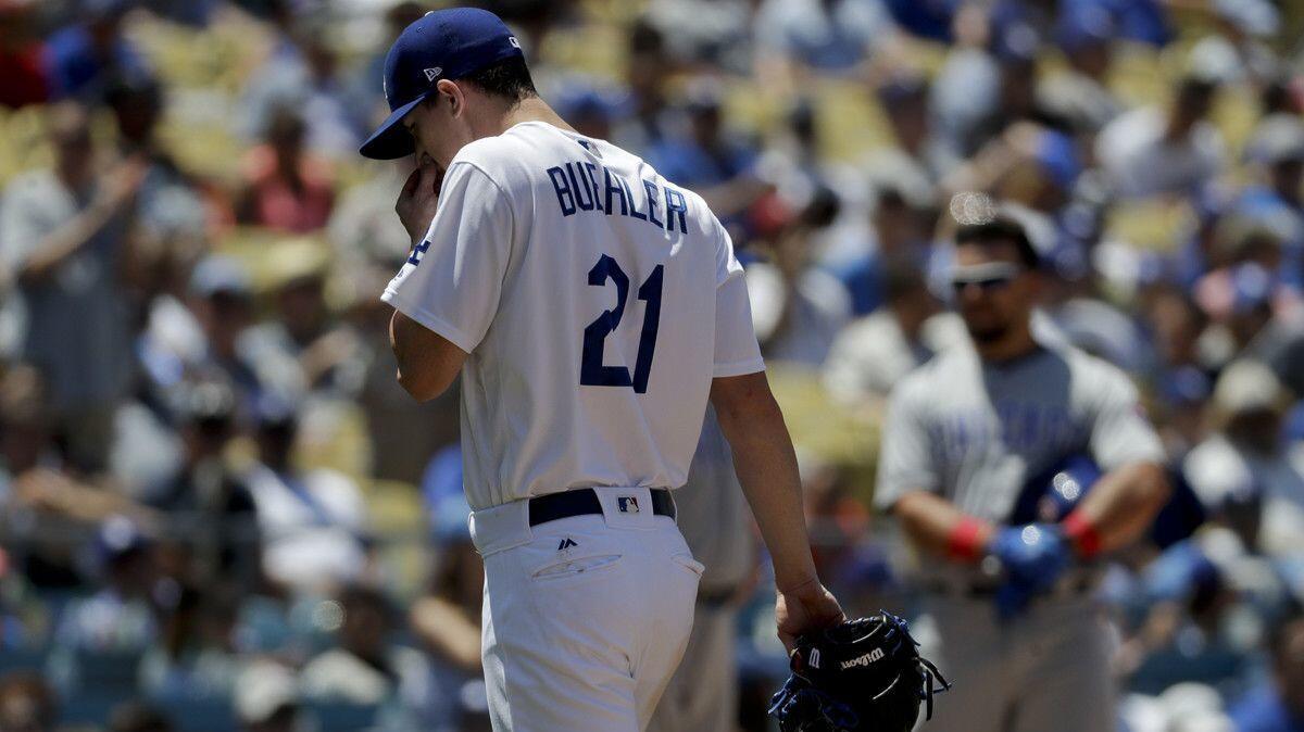 Dodger pitcher Walker Buehler wipes his face after being taken out of the game against the Chicago Cubs during the seventh inning on Thursday.