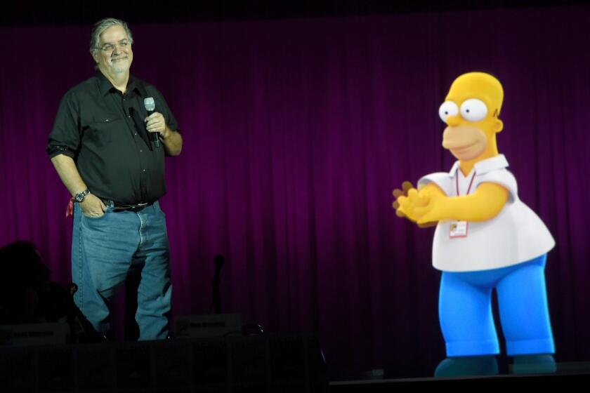 "Simpsons" creator Matt Groening with a projection of Homer, whose television cartoon family changed entertainment a quarter-century ago.