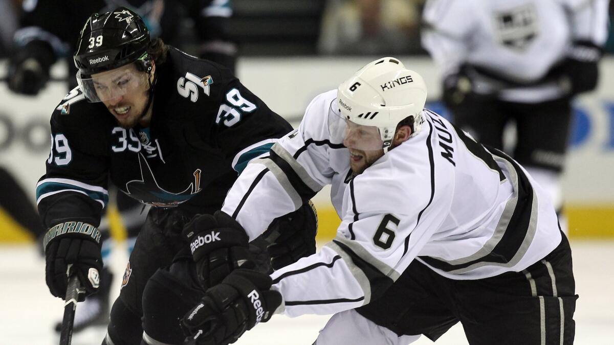 San Jose Sharks forward Logan Couture, left, and Kings defenseman Jake Muzzin battle for the puck during Game 7 of the Western Conference quarterfinals on April 30. The Kings will play the Sharks in their season opener Oct. 8 at Staples Center.