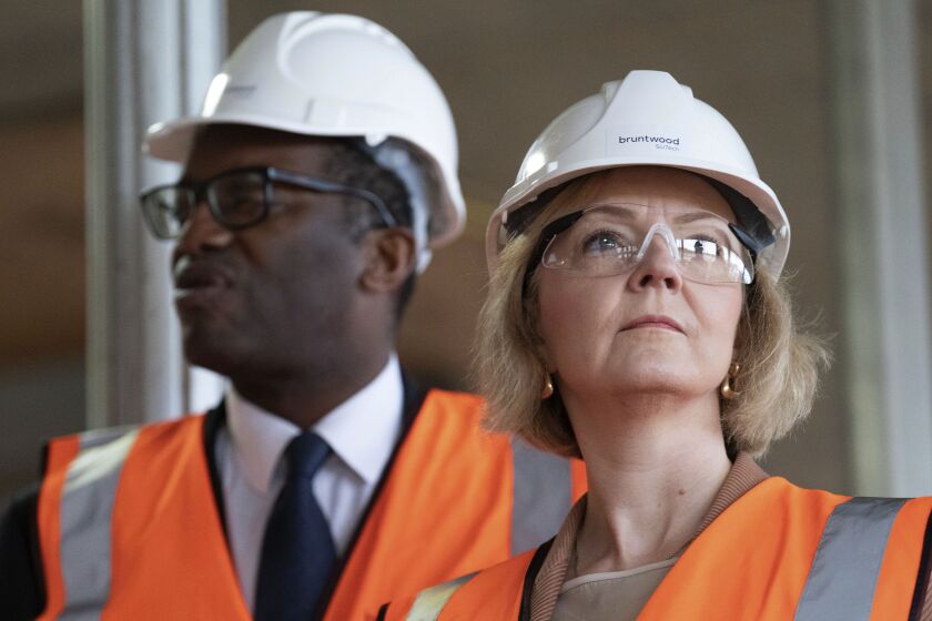 Britain's Prime Minister Liz Truss, foreground and Chancellor of the Exchequer Kwasi Kwarteng look on, during a visit to a construction site for a medical innovation campus, on day three of the Conservative Party annual conference at the International Convention Centre in Birmingham, England, Tuesday, Oct. 4, 2022. (Stefan Rousseau/Pool Photo via AP)
