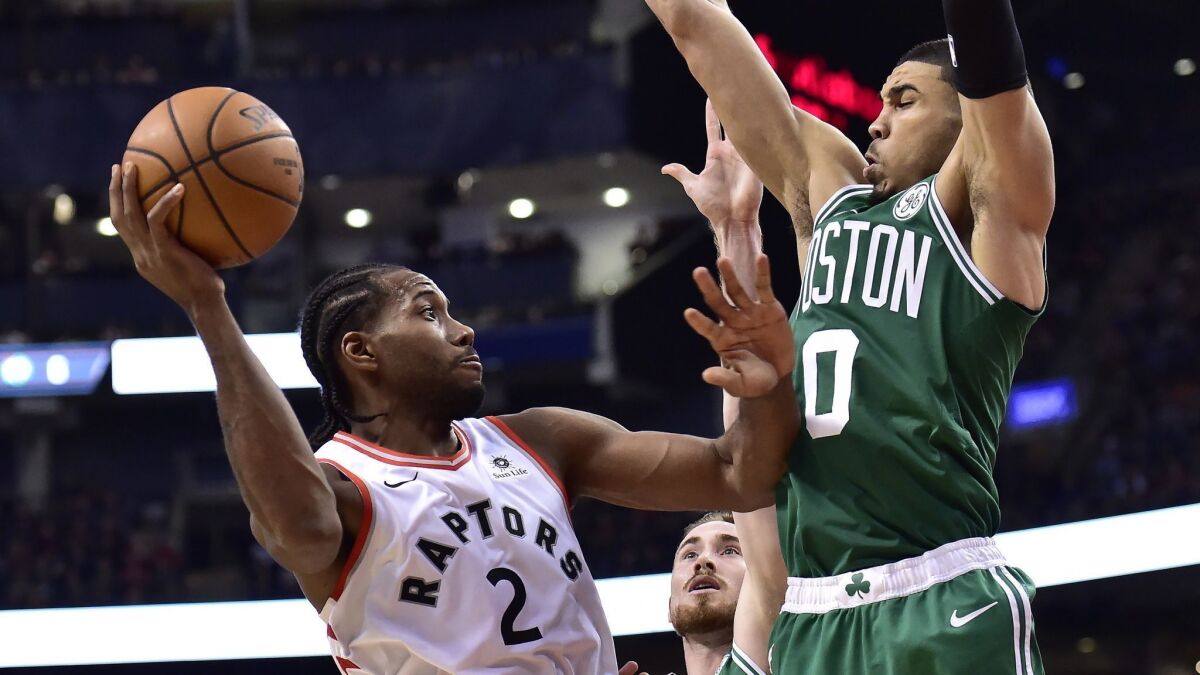Boston Celtics forward Jayson Tatum (0) and forward Gordon Hayward (20) pressure Toronto Raptors forward Kawhi Leonard (2) during the second half on Friday.