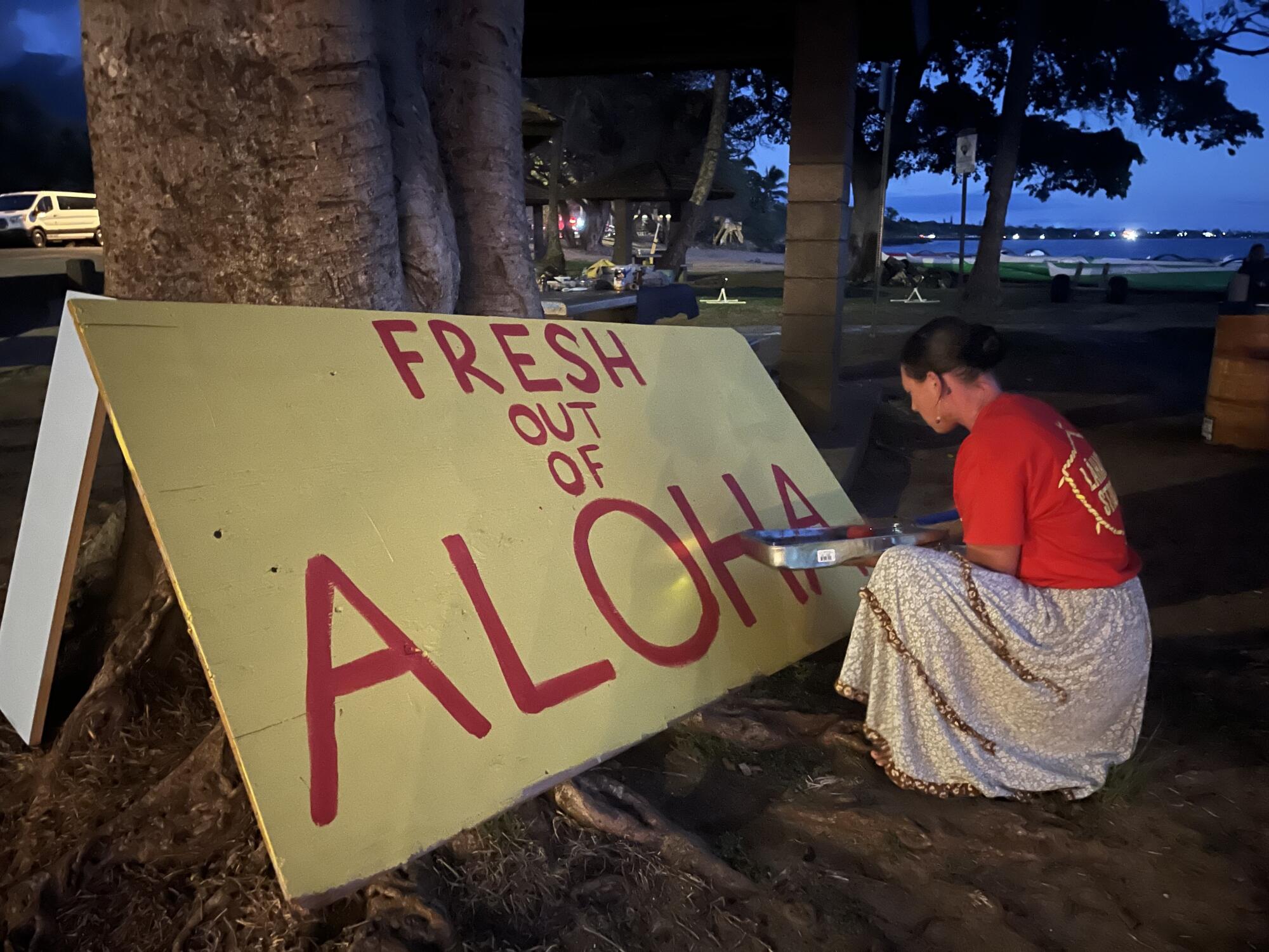 Katie Austin, a 35-year-old server, paints a sign protesting the reopening of West Maui.