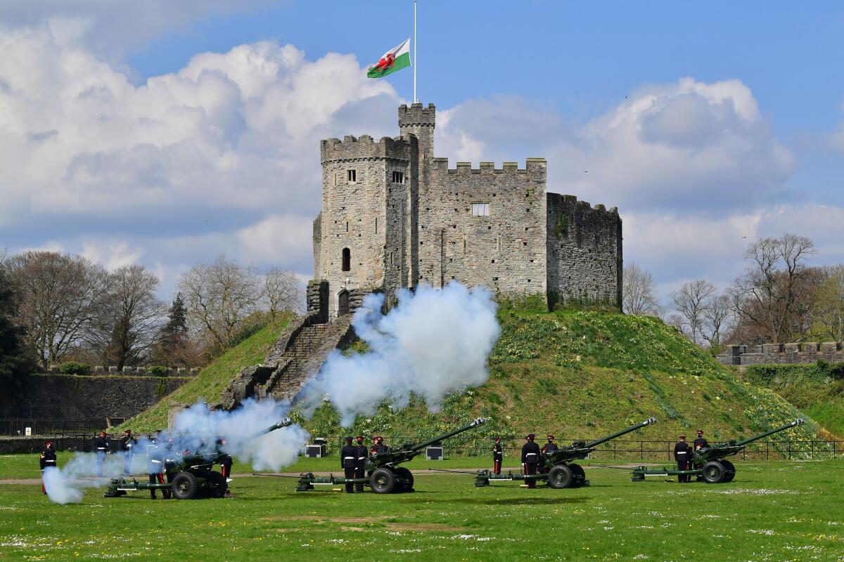 Smoke rises from cannons fired on the grounds of Cardiff Castle in Wales 