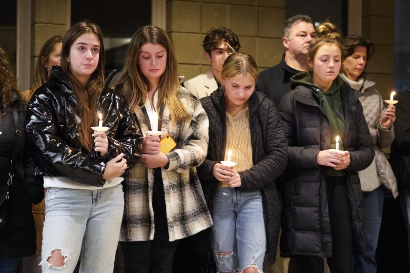 Students attend a vigil at LakePoint Community Church in Oxford, Mich., Tuesday, Nov. 30, 2021. Authorities say a 15-year-old sophomore opened fire at Oxford High School, killing several students and wounding multiple other people, including a teacher. (AP Photo/Paul Sancya)