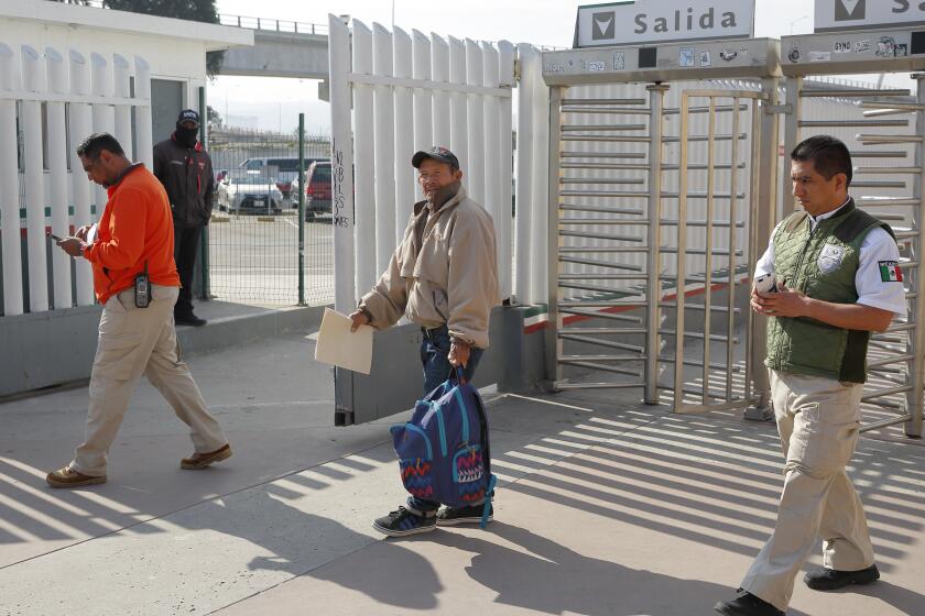 FILE - In this Jan. 29, 2019, file photo, migrant Carlos Catarldo Gomez, of Honduras, center, is escorted by Mexican officials after leaving the U.S., the first person returned to Mexico to wait for his asylum trial date as part of a new program "Remain In Mexico" policy in Tijuana, Mexico. The Supreme Court has ordered the reinstatement of the policy, saying that the Biden administration likely violated federal law by trying to end the Trump-era program that forces people to wait in Mexico while seeking asylum in the U.S. The decision immediately raised questions about what comes next for the future of the policy, also known as the Migrant Protection Protocols. (AP Photo/Gregory Bull, File)