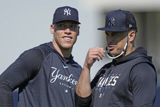 New York Yankees' Aaron Judge, left, and Giancarlo Stanton look to the stands before throwing out baseballs during a spring training baseball workout Monday, Feb. 20, 2023, in Tampa, Fla. (AP Photo/David J. Phillip)