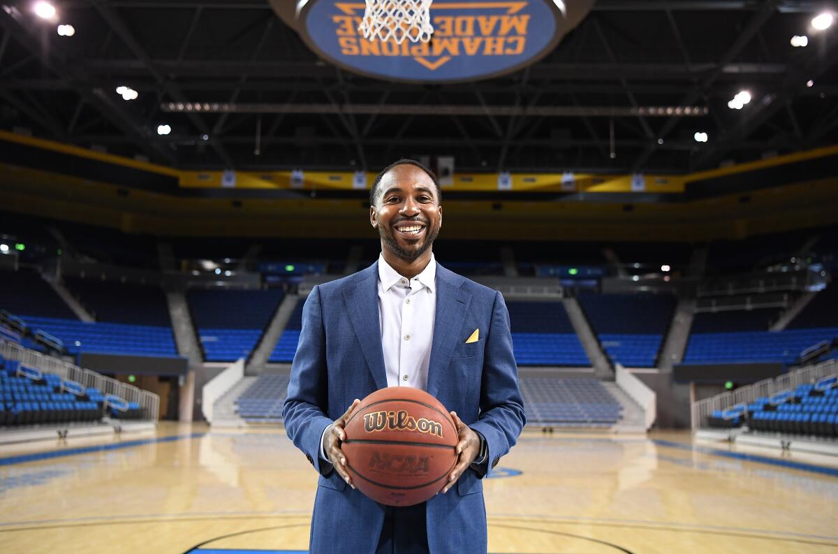 UCLA athletic director Martin Jarmond holds a basketball while standing in Pauley Pavilion.
