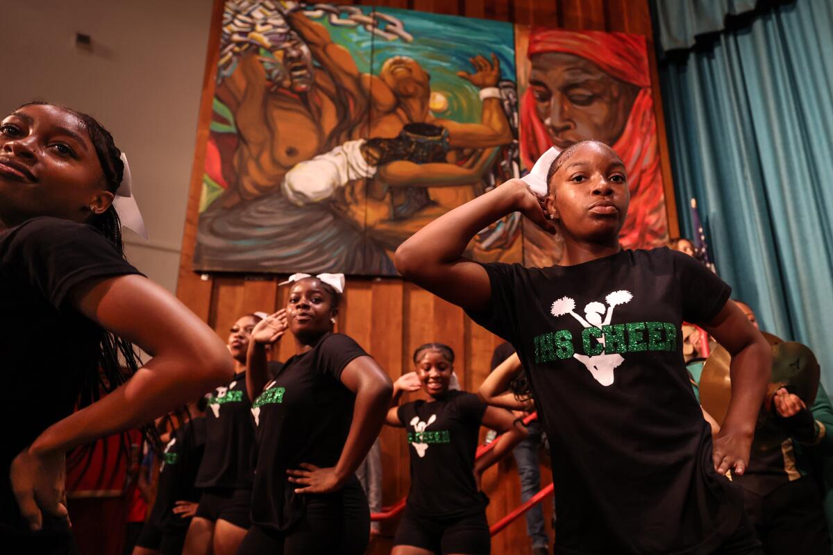 Inglewood High cheer squad members perform with the marching band during a school district conference at Morningside High.