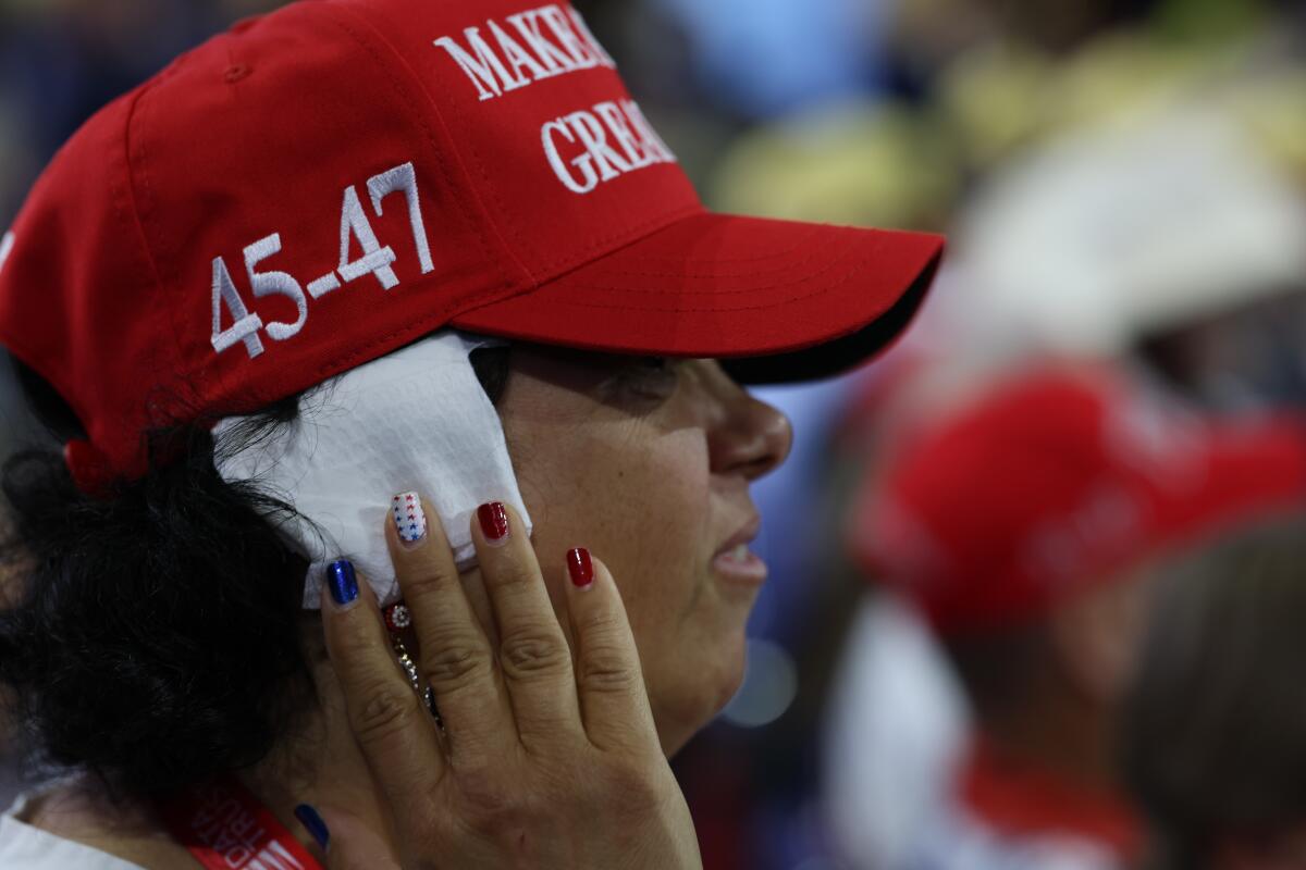 A woman in a red MAGA hat wears a bandage on her ear at the Republican National Convention.