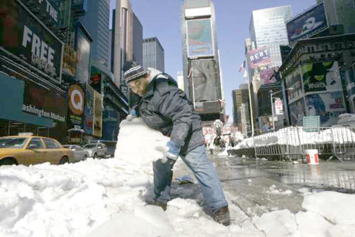 WONDERLAND'S CHARM FADES: Pablo Albert clears ice in Times Square as New York digs out from a record-setting storm. Clearing snow no longer means dumping it in the river, or piling it high to melt in the spring. These days, the city uses snow-melters.