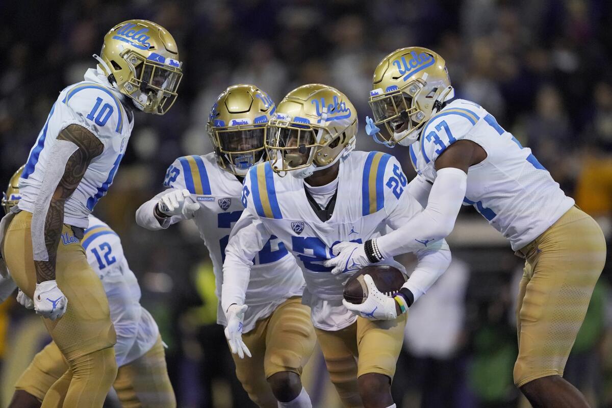 UCLA defensive back Devin Kirkwood celebrates with Ale Kaho, Obi Eboh and Quentin Lake.