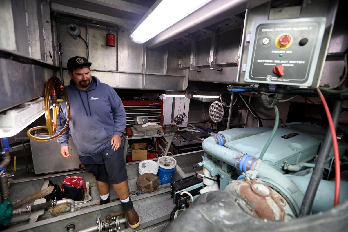 A man visits the engine room on a sport-fishing boat. 