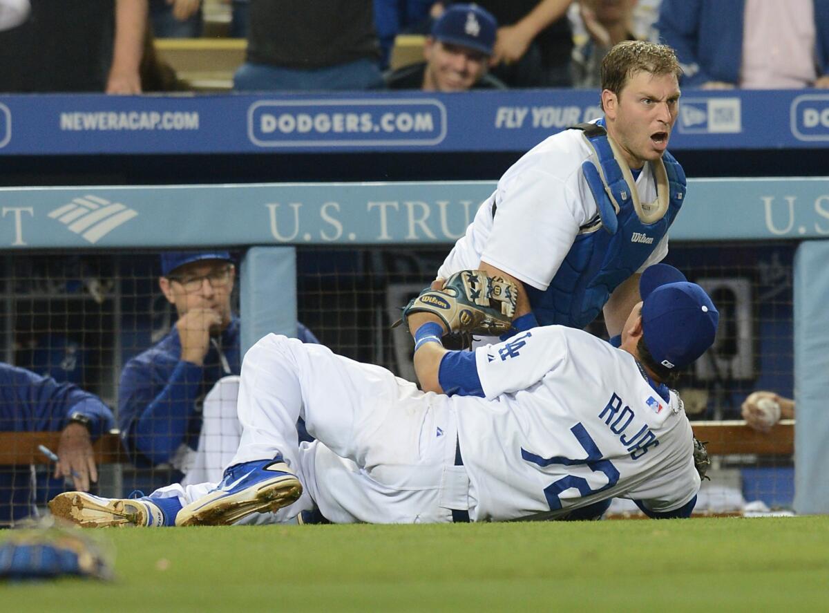 Catcher A.J. Ellis collides with Miguel Rojas after catching a pop foul by Arizona's Paul Goldschmidt in the eighth inning of the Dodgers' 6-4 win Saturday over the Diamondbacks.