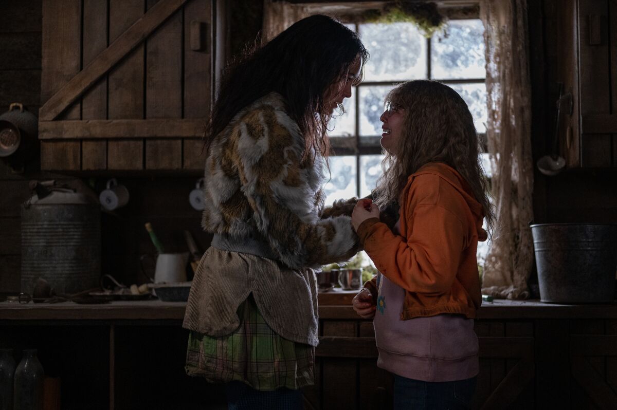 Lottie and Misty face each other and hold hands in the cabin.