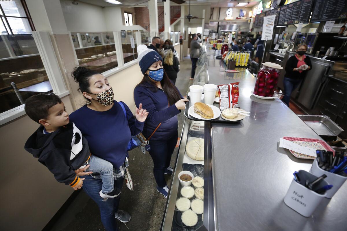 A family orders food at a restaurant counter