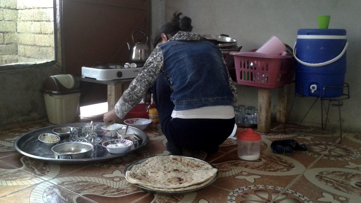 Seve's daughter-in-law, Amira, makes breakfast at the sparsely furnished house that was lent to them by fellow Yazidis in Baadra, Iraq. The women's relatives had to borrow thousands of dollars to smuggle them out of Islamic State territory.