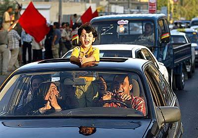 A car load of Iraqis celebrates the announcement of Iraqi sovereignty today.