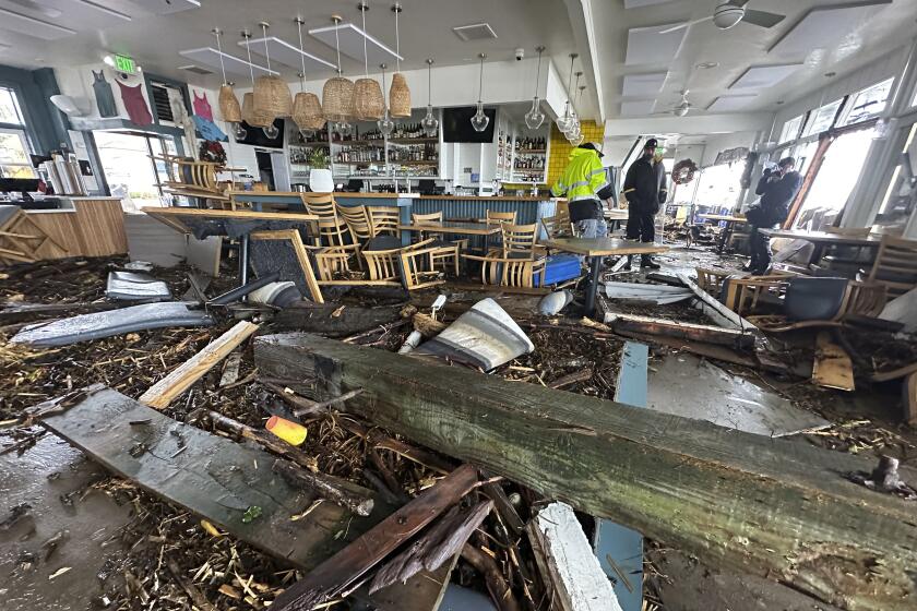 A support piece from the Capitola Wharf is seen inside the storm damaged Zelda's restaurant in Capitola, Calif., Thursday, Jan. 5, 2023. Giant ocean swells pushed debris through the front wall and a window, filling the interior with several inches of seawater. Damaging hurricane-force winds, surging surf and heavy rains from a powerful "atmospheric river" pounded California on Thursday, knocking out power to tens of thousands, causing flooding, and contributing to the deaths of at least two people. (Shmuel Thaler/The Santa Cruz Sentinel via AP)