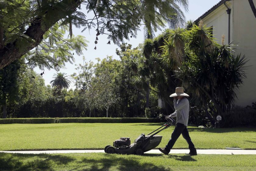File - In this Oct. 1, 2015 file photo, a gardener mows a lawn in Pasadena, Calif. State officials say residents of drought-weary California in November missed their 25 percent water conservation mandate for a second month running. The chair of the State Water Resources Control Board, says California remains on course to beat its long-term goal through February. (AP Photo/Nick Ut, File)