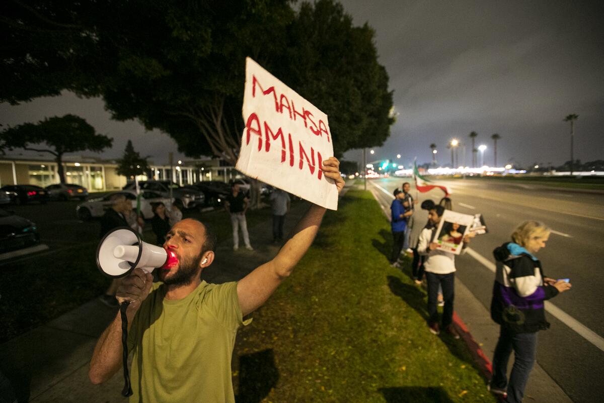 Saman Vakili, of Irvine, leads a chant Friday during a protest outside Costa Mesa City Hall.