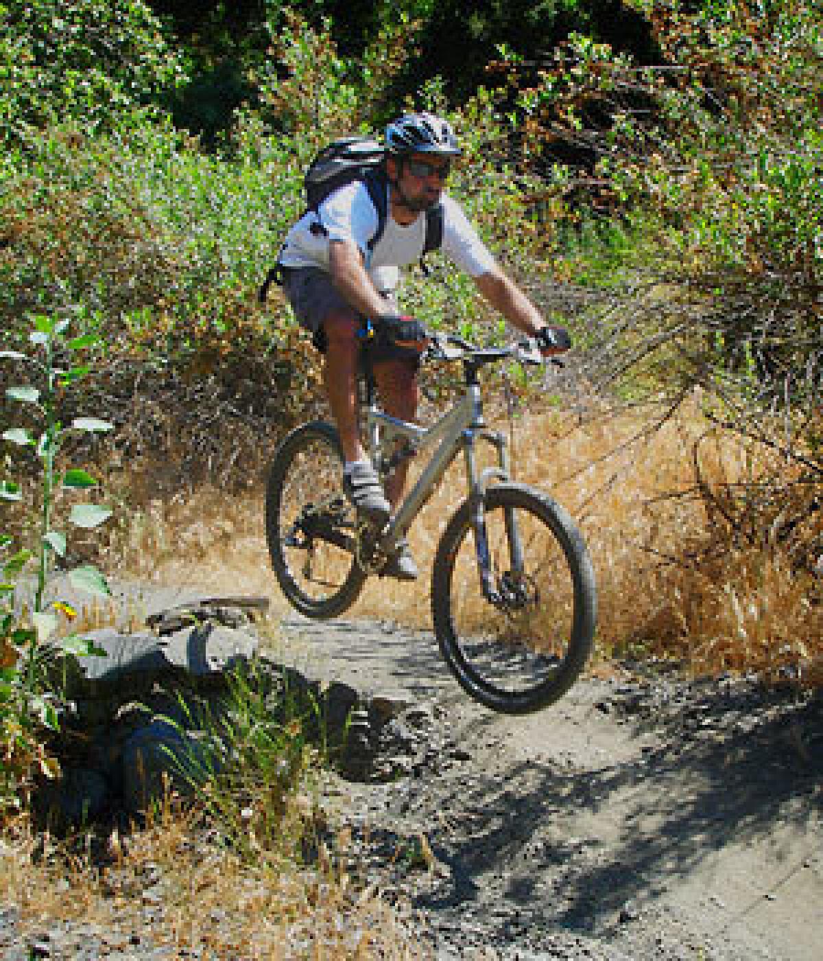 Ali Sagheb of Los Angeles jumps the trail along Sullivan Canyon, a favorite spot for mountain bike riders in Brentwood.
