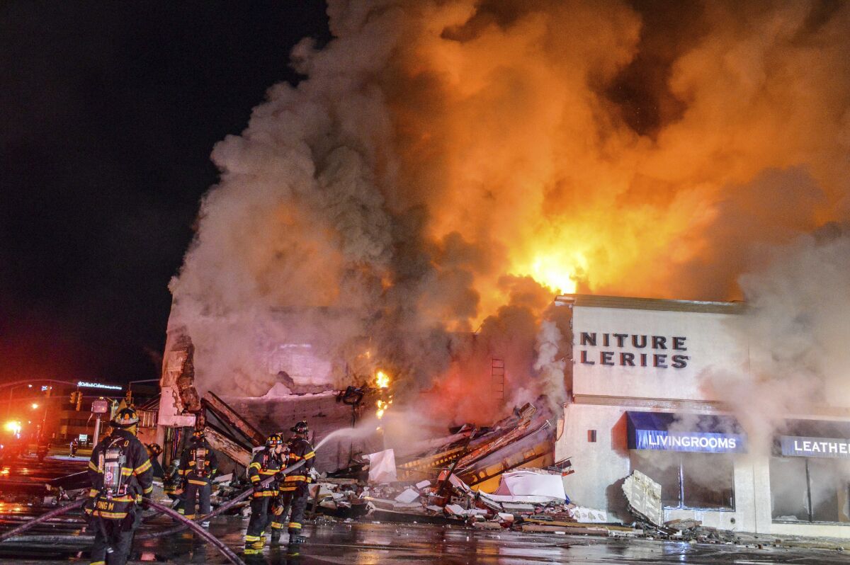 Emergency personnel work at the site of gas tanker accident in Rockville Centre, N.Y., early Wednesday, Feb. 16, 2022. A tanker carrying gasoline lost control, crashed into a vacant building and burst into flames on Long Island early Wednesday, injuring the truck's driver and three firefighters who responded, authorities said.(AP Photo/Alex DiGregorio)(AP Photo/Alex DiGregorio)