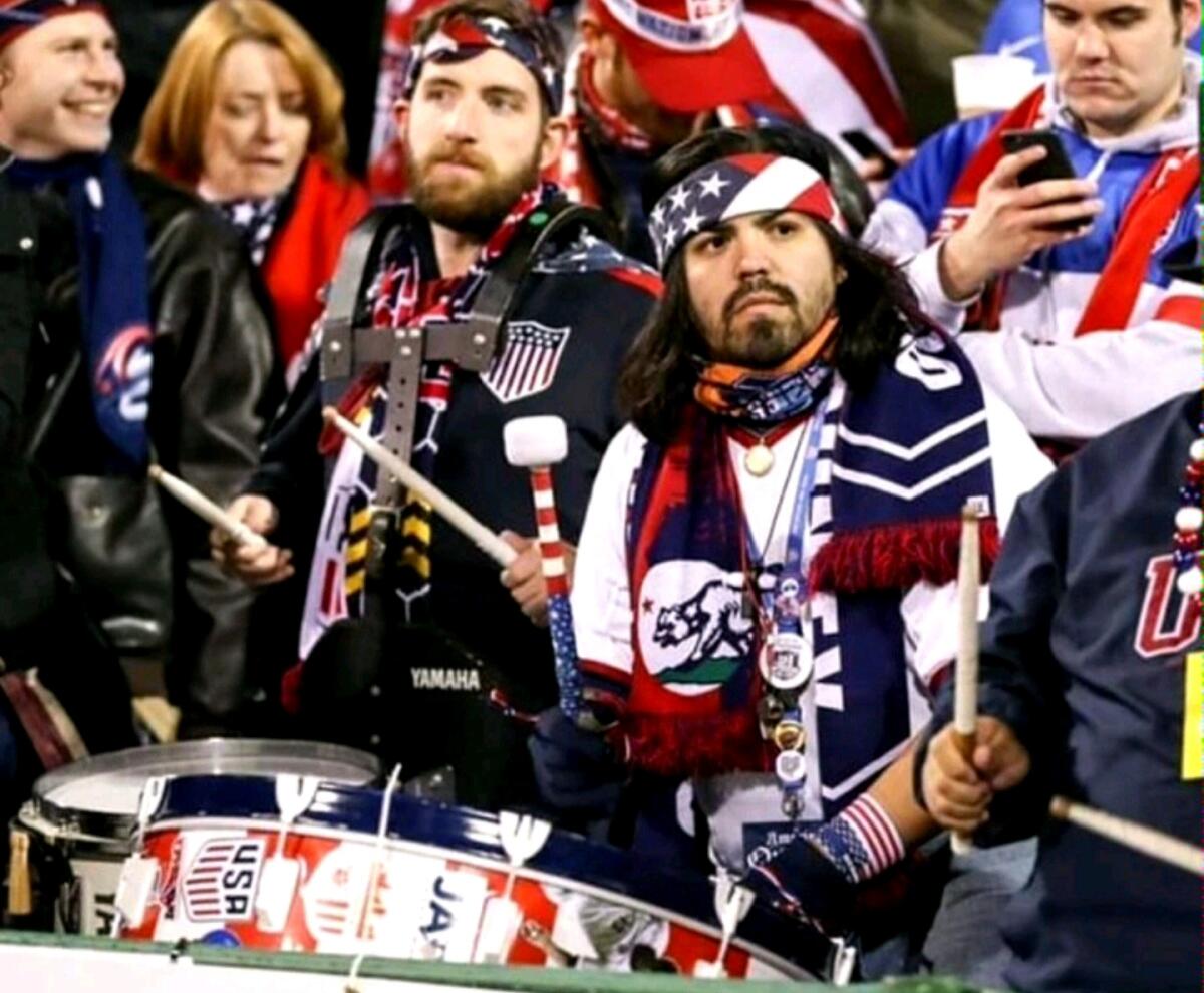 Ray Noriega, center, is decked in patriotic clothing while he plays a drum during a U.S. men's national team match.