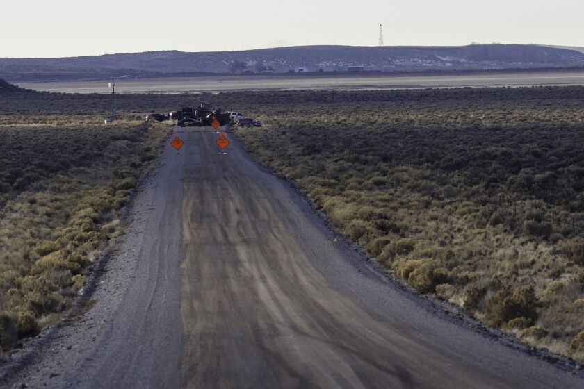 Law enforcement agencies operate a checkpoint on a road as a containment strategy surrounding the Malheur National Wildlife Refuge.