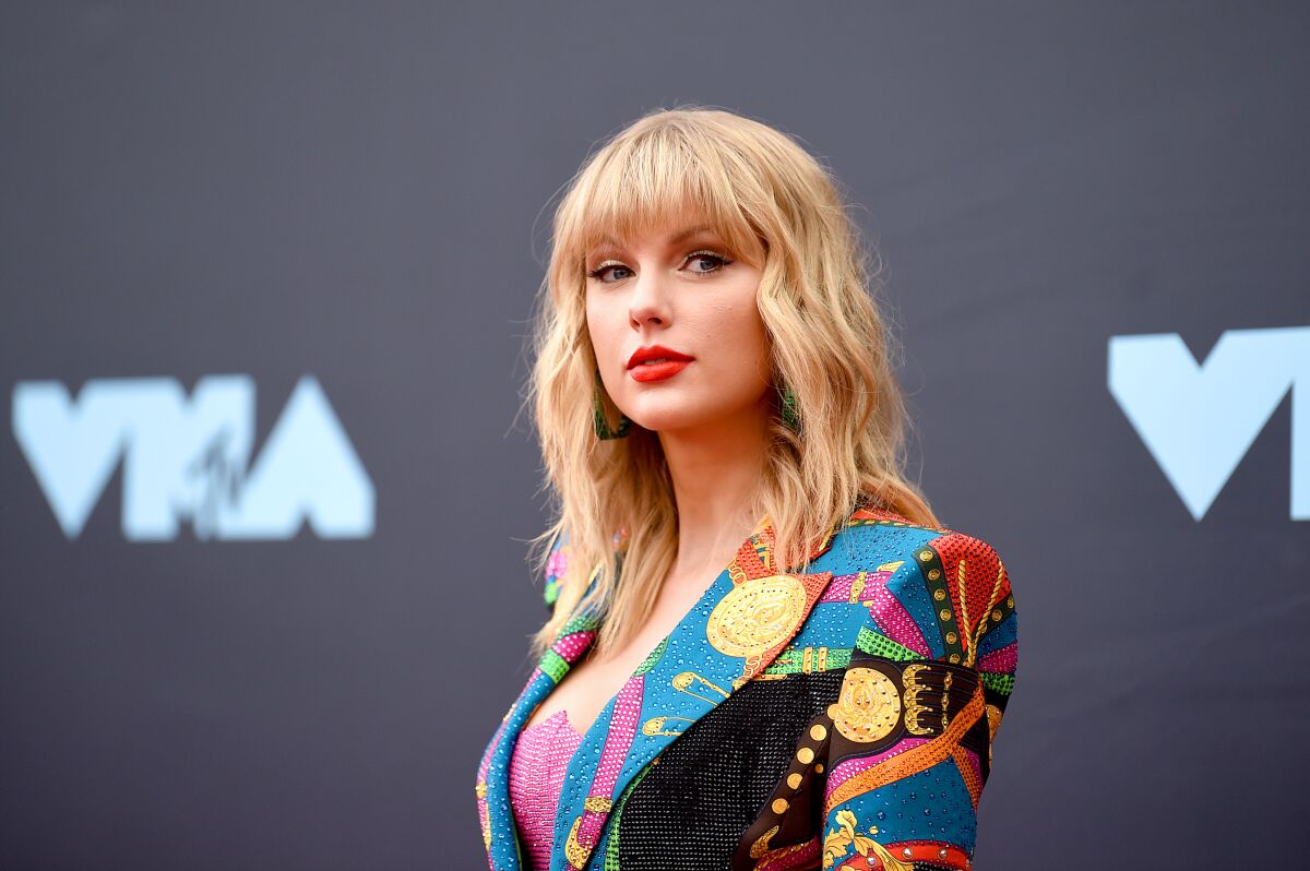 Taylor Swift in a multicolor jacket.