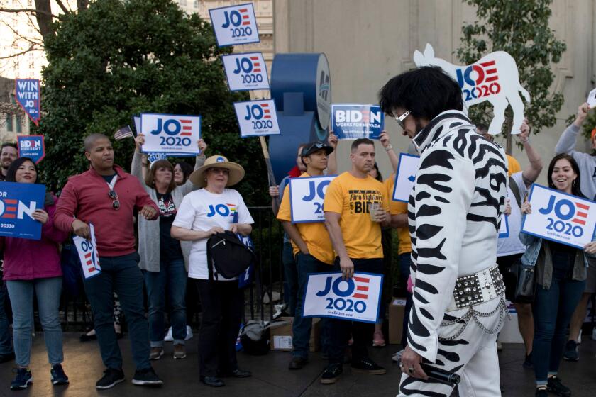 An Elvis impersonator walks past supporters of Democratic presidential hopeful former Vice President Joe Biden rallying outside the Paris hotel prior to the Democratic Presidential Debate hosted by NBC News and MSNBC with The Nevada Independent at Paris Hotel and Casino in Las Vegas, Nevada, on February 19, 2020. - Democrat rival presidential hopefuls will meet on the Democratic debate stage on February 19 in Las Vegas ahead of the Nevada Caucus on February 22. (Photo by Bridget BENNETT / AFP) (Photo by BRIDGET BENNETT/AFP via Getty Images)
