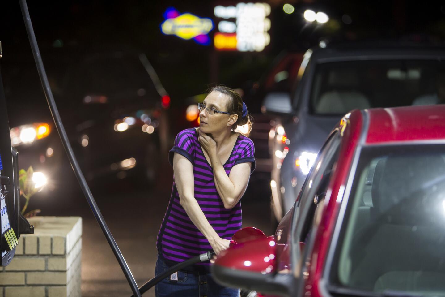 Beth Johnson fills up her car after waiting in line at a Sunoco gas station in advance of Hurricane Matthew in Mt. Pleasant, S.C., Tuesday, Oct. 4, 2016.