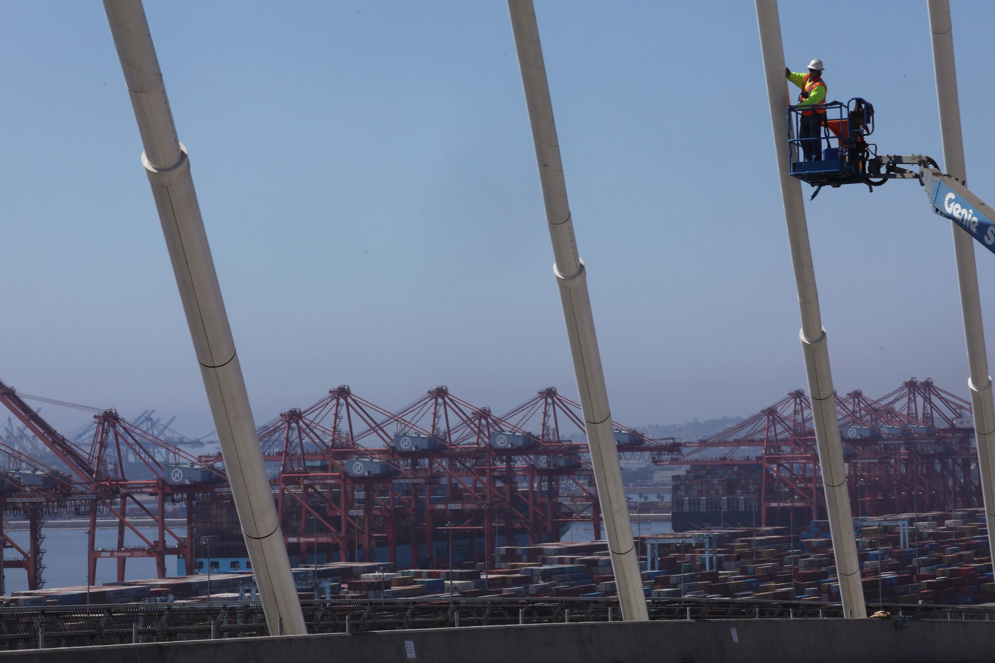 A worker on a lift works on bridge cables
