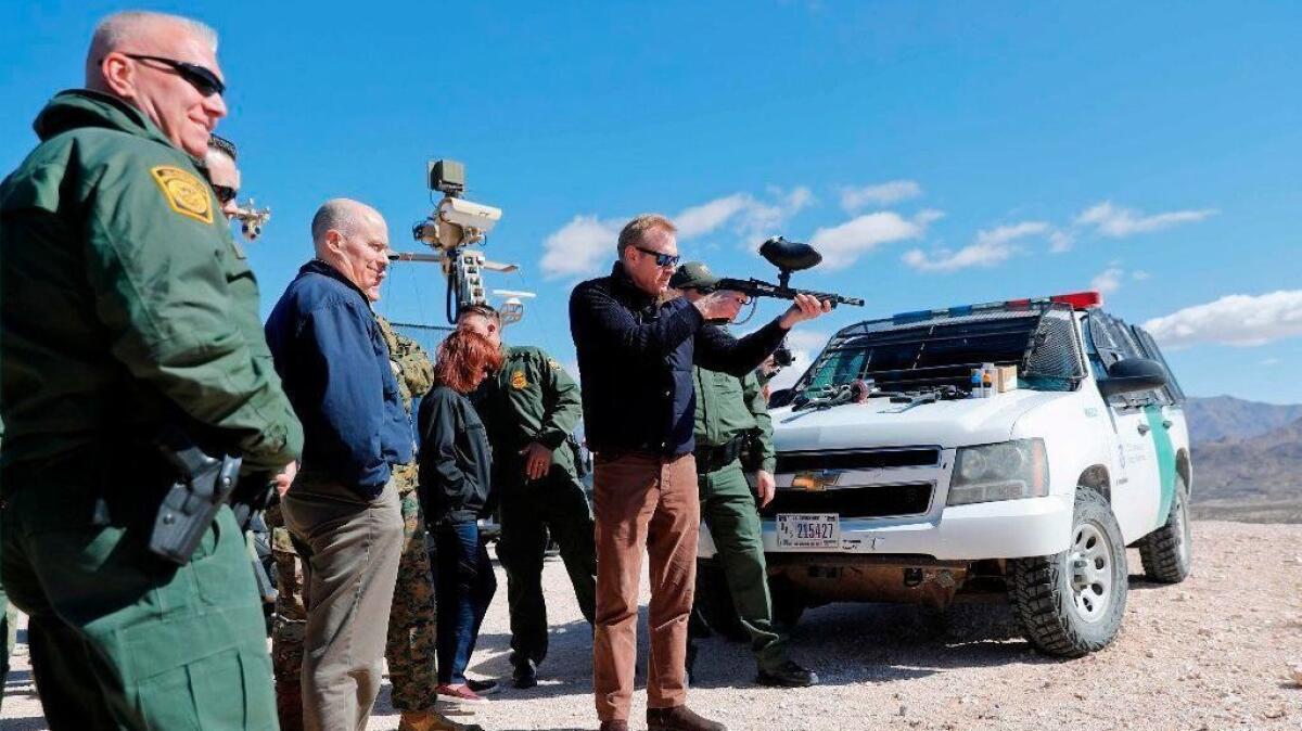 Acting Defense Secretary Patrick Shanahan fires a paintball gun modified to shoot pepper balls in Sunland Park, N.M., during a tour of the U.S.-Mexico border.