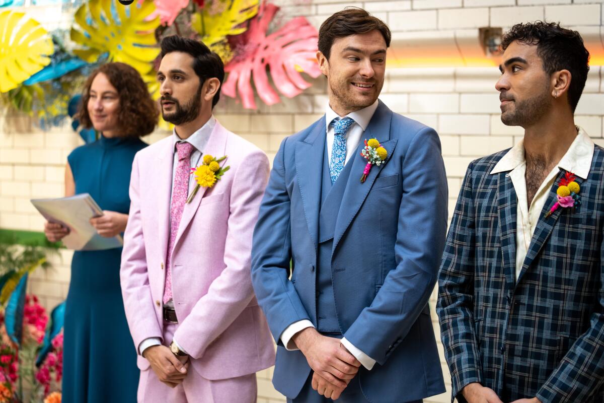 A woman and three men in colorful suits at a wedding