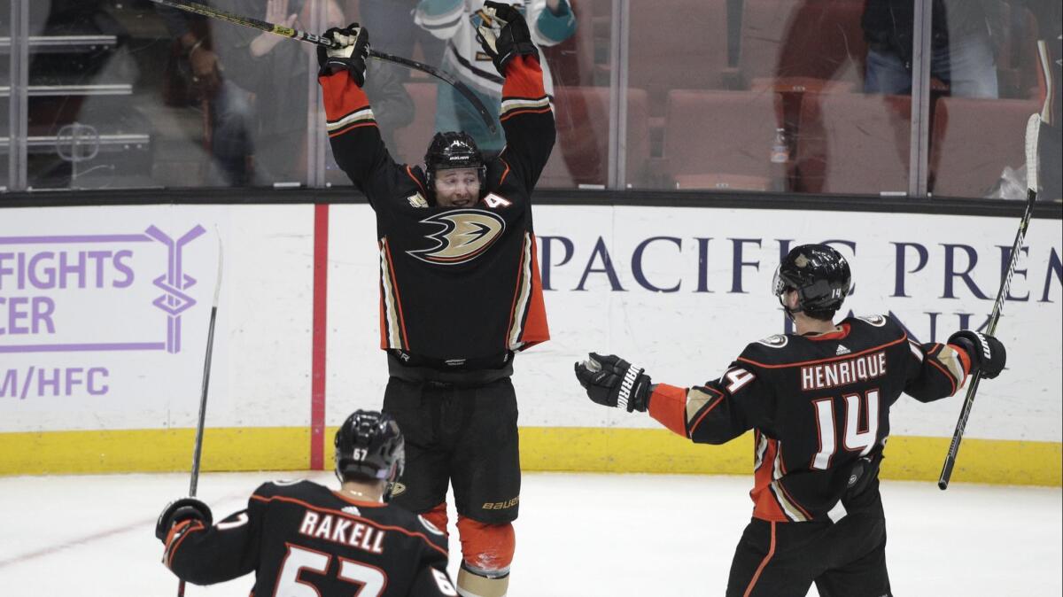 Ducks' Cam Fowler, center, celebrates his hat trick with Adam Henrique and Rickard Rakell in an overtime win against the Columbus Blue Jackets on Sunday.