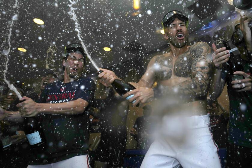 Minnesota Twins' Kenta Maeda, left, and Carlos Correa celebrate after the team's 8-6 win over the Los Angeles Angels in a baseball game Friday, Sept. 22, 2023, in Minneapolis. The Twins clinched the AL Central title. (AP Photo/Abbie Parr)