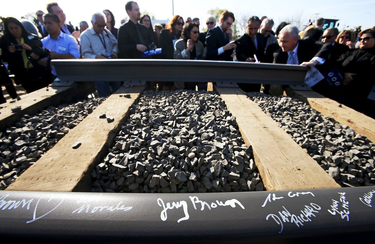 Guests sign a rail segment during a groundbreaking ceremony for a California bullet train station in Fresno on Jan. 6, 2015.