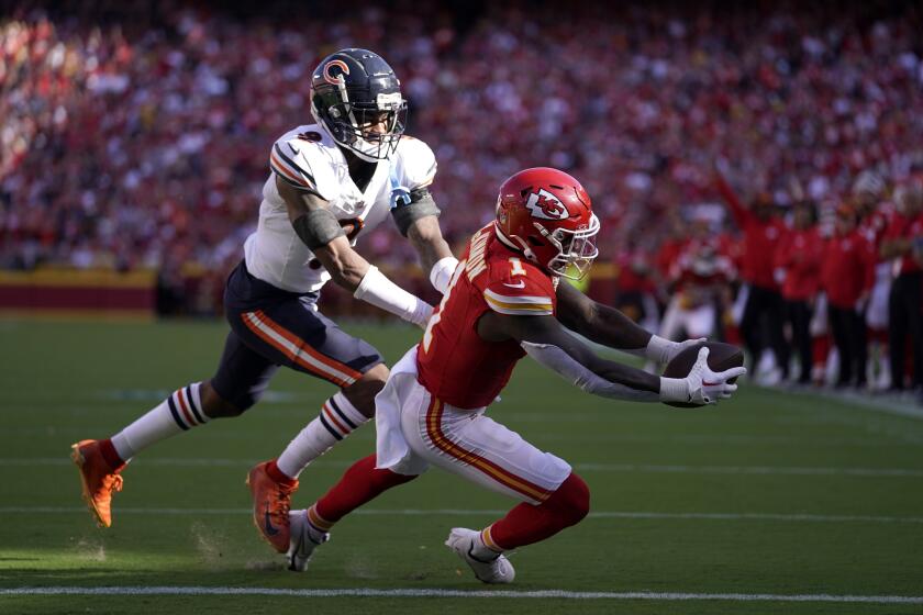 Kansas City Chiefs running back Jerick McKinnon (1) catches a touchdown pass as Chicago Bears safety Jaquan Brisker defends during the first half of an NFL football game Sunday, Sept. 24, 2023, in Kansas City, Mo. (AP Photo/Ed Zurga)